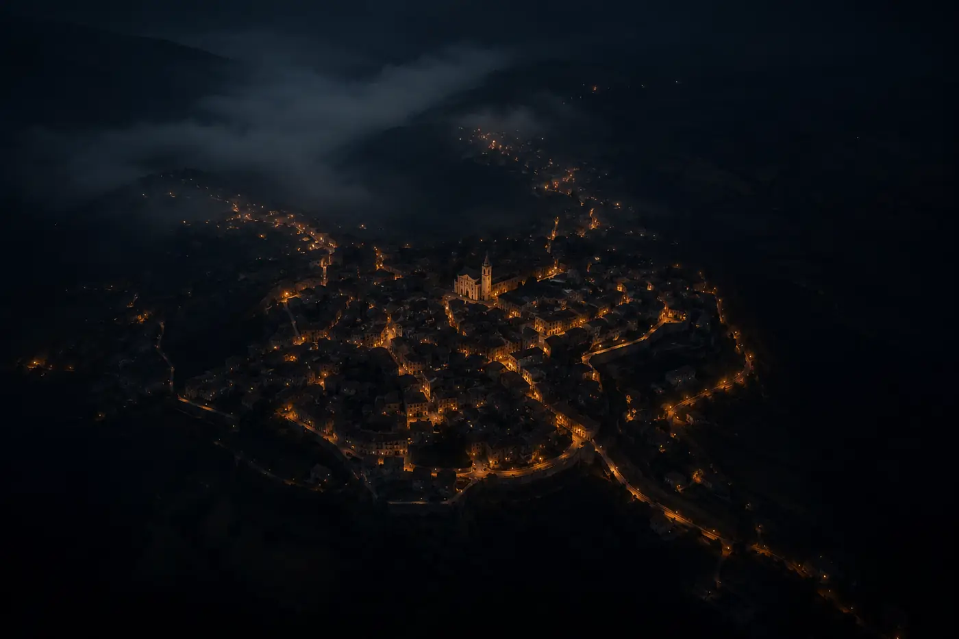 Veduta aerea notturna di un paese, con le strade illuminate